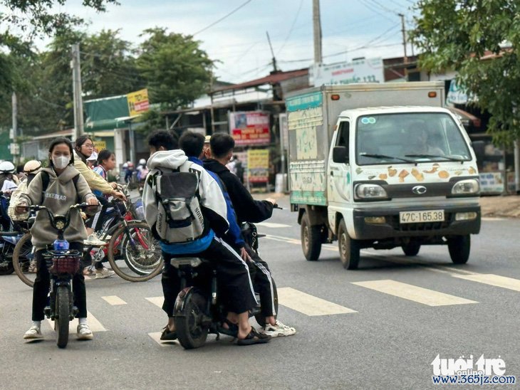 Vẫn chở ba, không mũ bảo hiểm phóng nhanh trước cổng trường - Ảnh 2.